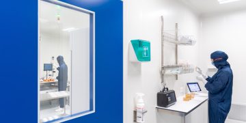 a person in a lab coat looking at a mirror
