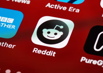 Detailed view of the Reddit app icon on a smartphone screen displaying popular applications.