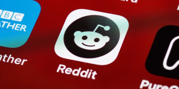 Detailed view of the Reddit app icon on a smartphone screen displaying popular applications.