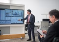 Professional conducts data analysis presentation in a modern office setting.