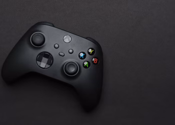 Closeup of a black gaming controller on a dark backdrop, perfect for tech themes.