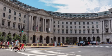 Street view of a historic building in Washington, DC, showcasing architecture and urban life.