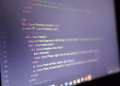 Illuminated HTML code displayed on a computer screen, close-up view.