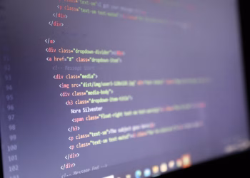 Illuminated HTML code displayed on a computer screen, close-up view.