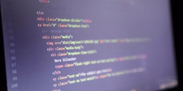 Illuminated HTML code displayed on a computer screen, close-up view.