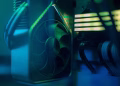 Detailed close-up of a computer cooling fan inside a custom PC with LED lighting, emphasizing technology and design.