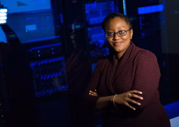 Confident woman in data center, showcasing tech expertise.