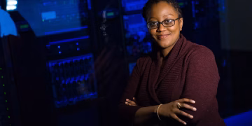 Confident woman in data center, showcasing tech expertise.