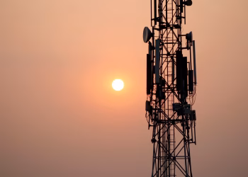 A striking silhouette of a communication tower against a vibrant sunset sky.