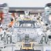 Robotic arms assembling a car chassis on a factory line.
