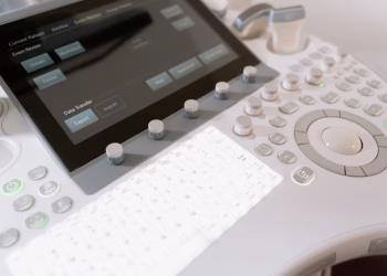 Detailed view of a medical ultrasound machine control panel with buttons and screen.