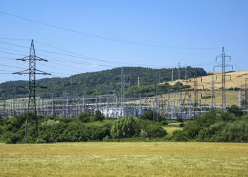 Electric transmission towers against a rural landscape, showcasing energy infrastructure.