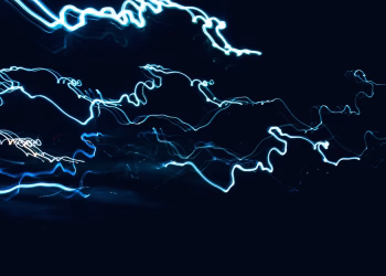 Dynamic abstract design of blue light streaks over black backdrop, capturing movement.