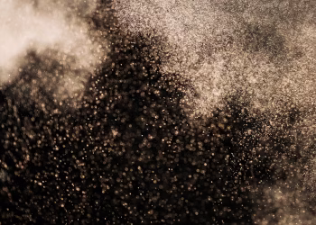 Stunning abstract image featuring gold particles floating against a dark background, creating a magical atmosphere.