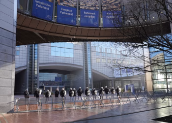 Police officers stand guard outside the European Parliament building in Brussels, Belgium.