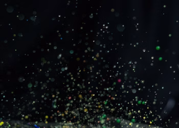 Vibrant multicolor paint splatter captured in motion with a dark backdrop, ideal for creative design.