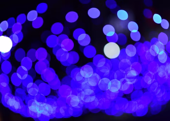 Abstract blue bokeh lights create a vibrant, dreamy night scene.
