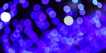 Abstract blue bokeh lights create a vibrant, dreamy night scene.