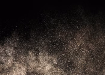A mesmerizing display of dust particles floating against a dark backdrop, creating a textured effect.