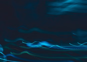 Dynamic abstract image of blue light streaks on a dark background, evoking motion and energy.