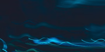 Dynamic abstract image of blue light streaks on a dark background, evoking motion and energy.