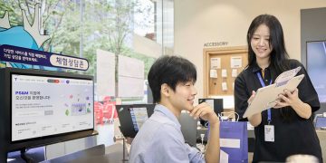 T월드 매장에서 직원이 태블릿을 들고 고객과 상담하는 모습