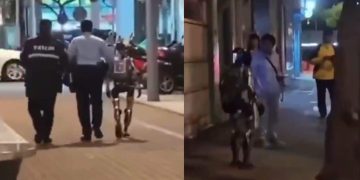 야간 보도에서 현장 관계자 두 명과 휴머노이드 로봇이 함께 걷는 장면