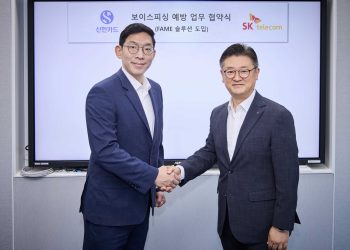 SKT와 신한카드 관계자가 FAME 공급 계약 뒤 악수하는 모습