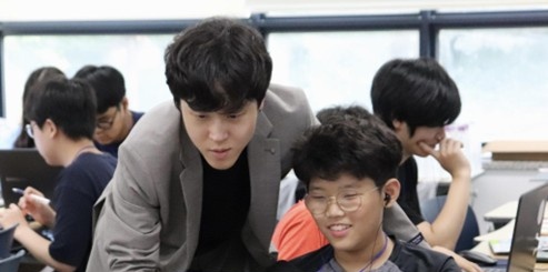 신한 AI 크리에이터 캠프에서 강사가 중학생의 생성형 AI 영상 제작을 지도하는 모습