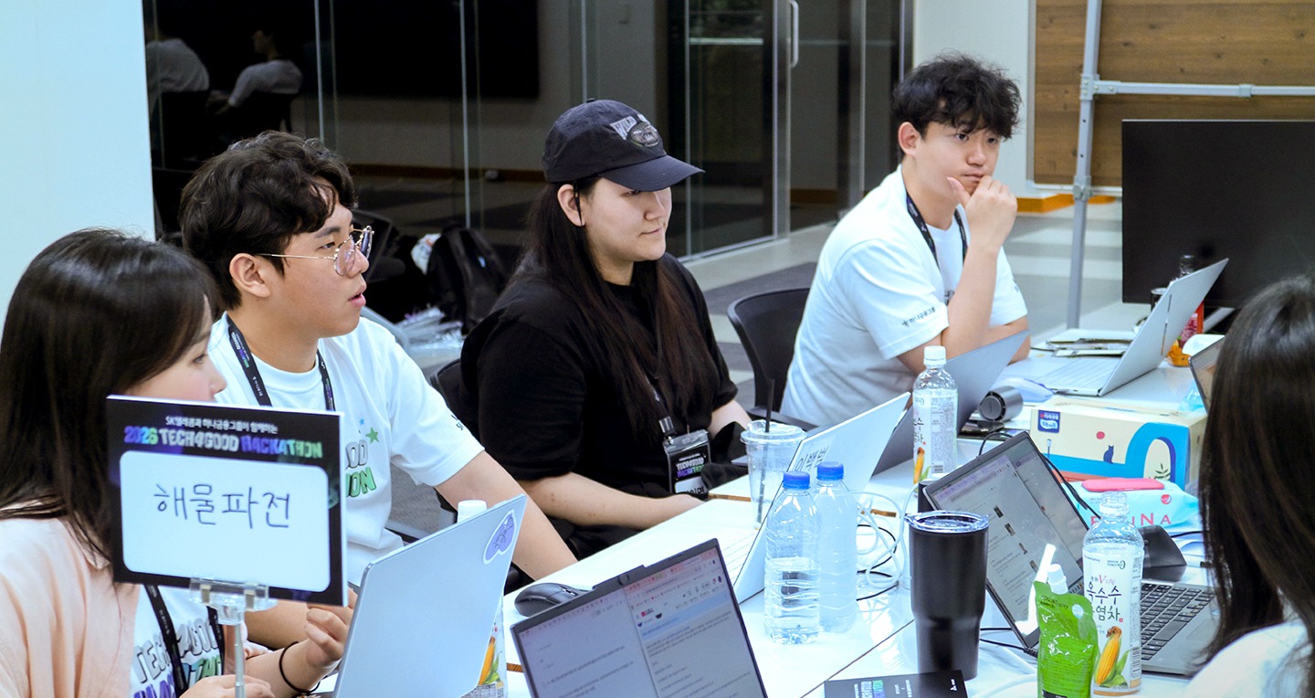 TECH4GOOD 해커톤 참가자들이 노트북으로 포용 AI 시제품을 개발하는 모습